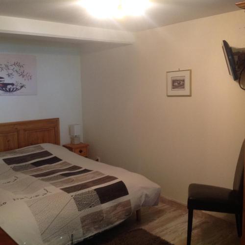 une chambre avec un lit et une chaise dans l'établissement Birgele, à Riquewihr