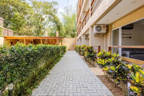 a walkway in front of a building with plants at Condomínio Eclipse Village, Praia de Juquehy in São Sebastião