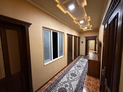 a hallway with a room with a rug and a window at Apartments Rakhmatullaev in Samarkand