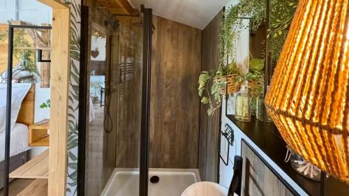 a bathroom with a shower and a sink at Romantic colonial lodge with hot tub in Baddiley