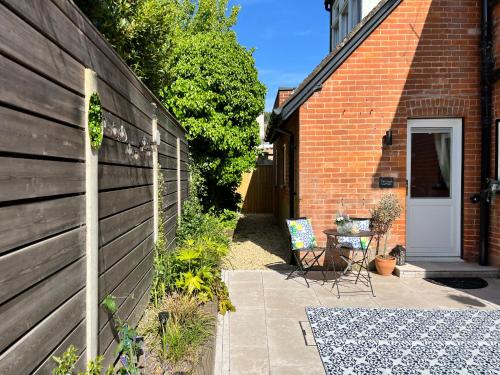 a patio with a table next to a brick building at Cliff Cottage in Canford Cliffs