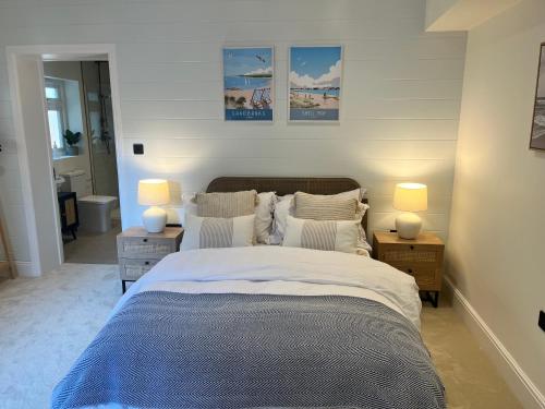 a bedroom with a large bed and two lamps at Cliff Cottage in Canford Cliffs