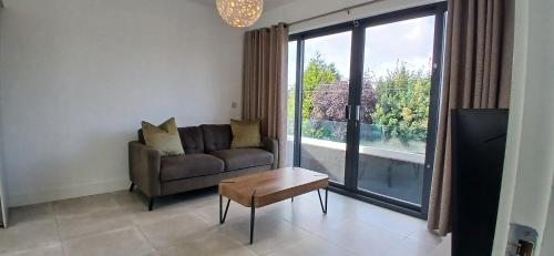 a living room with a couch and a large window at Newly Refurbed 2BD Wraparound Balcony 5km to City in Dublin