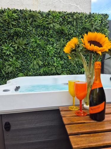 a bottle of wine and two glasses on a table at JUNGLE HOT TUB, games room, near eateries, micro brewery, pubs, beauty salons and boutique shops, Argyle, free Netflix, in the heart of Plymouth - Dogs welcome - Hosted by Absolute Accommodation Plymouth in Plymouth