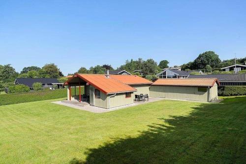 a house with an orange roof on a grass field at SJ299-Hejlsminde-Poppelvaenget-4 in Hejlsminde