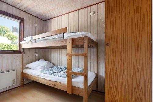 a bunk bed in a tiny house with a ladder at SJ299-Hejlsminde-Poppelvaenget-4 in Hejlsminde