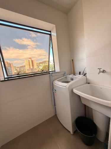 Un baño con inodoro, lavabo y ventana. en LK Santa Efigênia 2, en Belo Horizonte