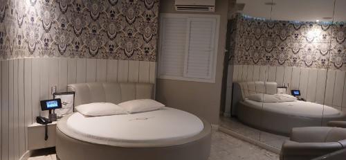 a room with two beds and a tub in it at Motel Decameron (Adults Only) in Salvador
