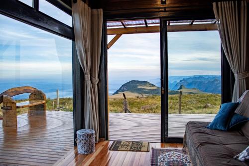 a room with a large window with a view of the mountains at Experiência Premium - Montanha do Sol in Aiuré