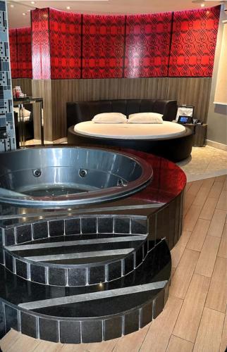 a jacuzzi tub in a room with a bed at Motel Decameron (Adults Only) in Salvador