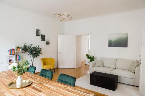 a living room with a couch and a table and chairs at Bright City Apartment in Graz