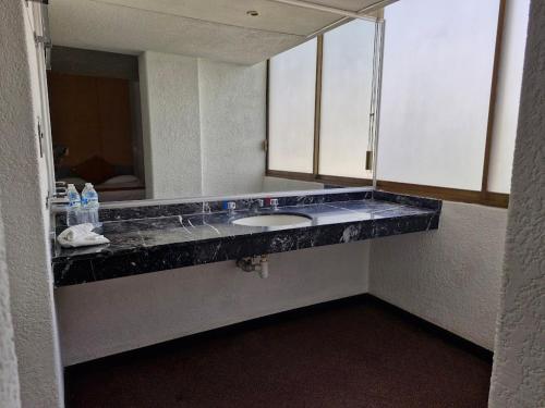 a bathroom with a sink and a mirror at Parador del Río by Flamingo Hotels Group in Irapuato
