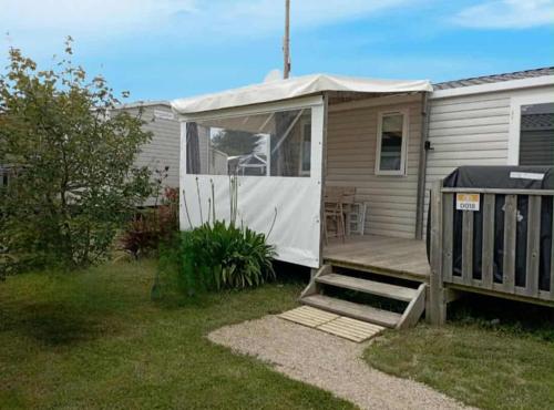 a mobile home with a porch and a deck at mobil-home bord de plage in Sarzeau