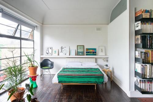 a bedroom with a bed and a book shelf at Canning Town Serviced Apartment in London