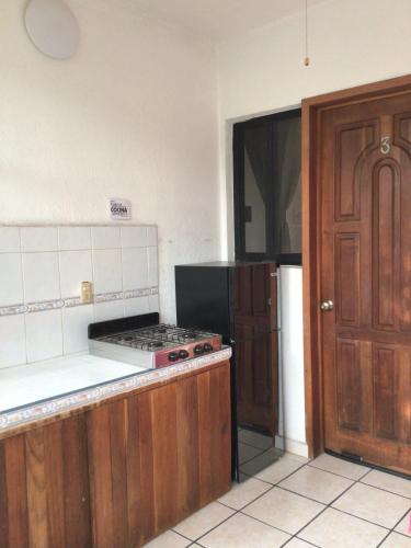an empty kitchen with a stove and a refrigerator at Hotel Villa Tulipanes in Zihuatanejo
