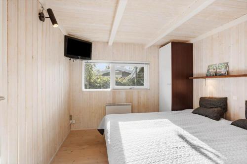 a bedroom with a bed and a tv on the wall at LL253-Tranekaer-Engvej-1-B in Tranekær
