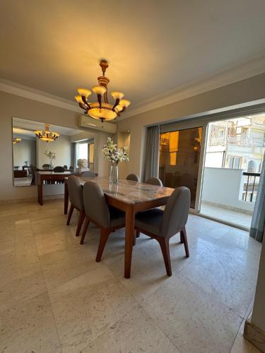 a dining room with a wooden table and chairs at VESTA - Nile Zamalek Residence in Cairo