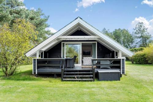 a black tiny house with a porch on a field at LL248-Humble-Birkevaenget-9 in Humble