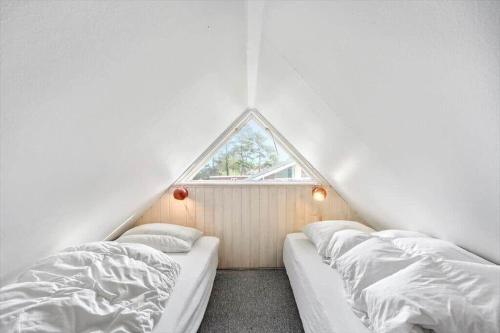 a attic bedroom with two beds and a window at LL204-Humble-Vildrosevej-16 in Humble