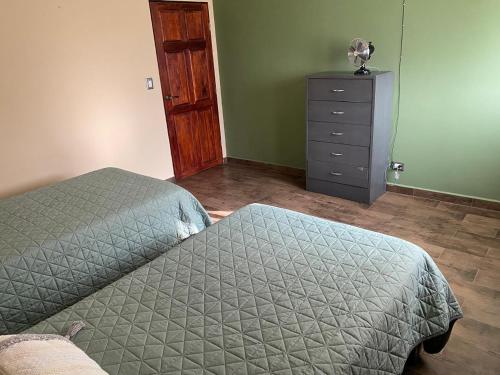 a bedroom with a bed and a dresser at Villa Ojo de Agua in Hacienda Ojo de Agua