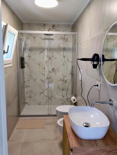 a bathroom with a shower and a sink and a toilet at Cabrí rooms in Vieste