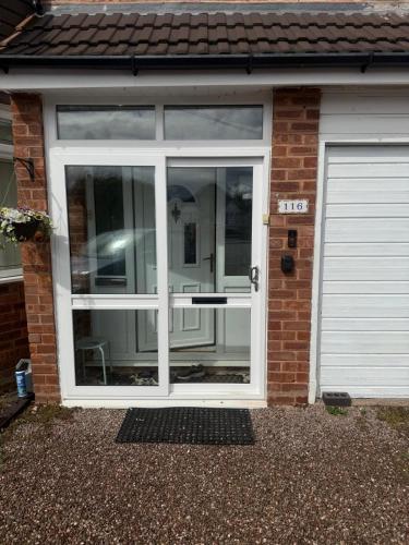 a white door on a house with a garage at The RS Inn Cozy Homestay Premium Private Rooms With Parking Near Birmingham Airport, Lake Park For Solo, Couples & Family in Kingshurst