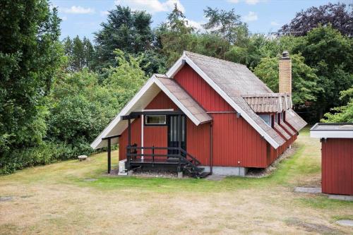 a red house with a chimney on the side of it at LL238-Tranekaer-Engvej-17 in Tranekær