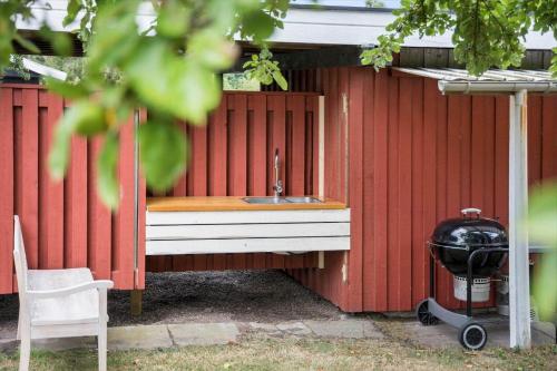 a red shed with a sink and a grill at LL238-Tranekaer-Engvej-17 in Tranekær