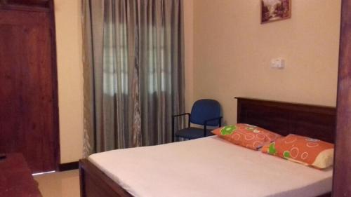 a bedroom with a bed and a blue chair at LEAF resorts in Gampola
