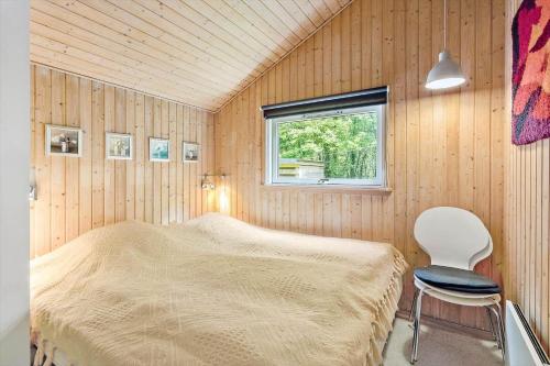 a bedroom with a bed and a chair in it at LL209-Humble-Ristingevej-141-A in Humble