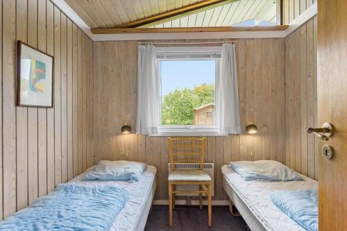 two beds in a room with a window and a chair at LL241-Tranekaer-Bellisvej-39 in Tranekær