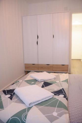 a bedroom with a bed with two pillows on it at Tesla Apartments 1 in Kragujevac