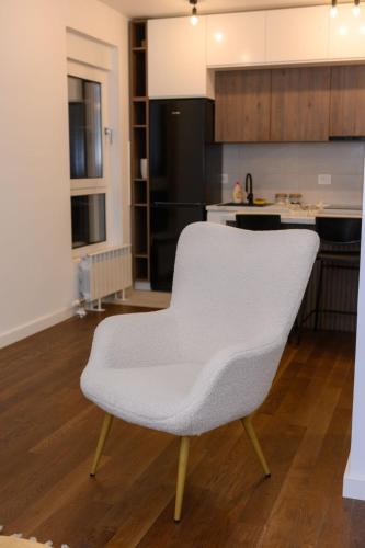 a white chair sitting in the middle of a kitchen at Tesla Apartments 1 in Kragujevac