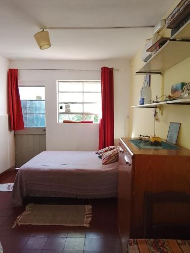 a bedroom with a bed and a window with red curtains at Tiny-house in Concordia