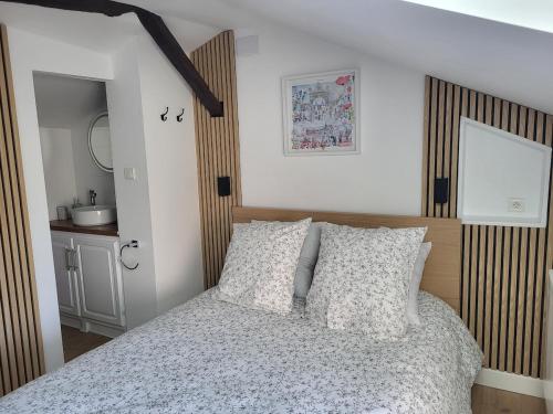 a bedroom with a bed with a wooden headboard at Appartement au pied de la forteresse in Châtel-sur-Moselle