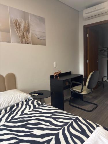 a bedroom with a bed and a desk and a chair at Casa Joinville in Joinville