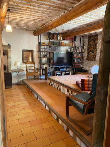 a living room with a couch and a tv at Il était une fois à Lagnes in Lagnes