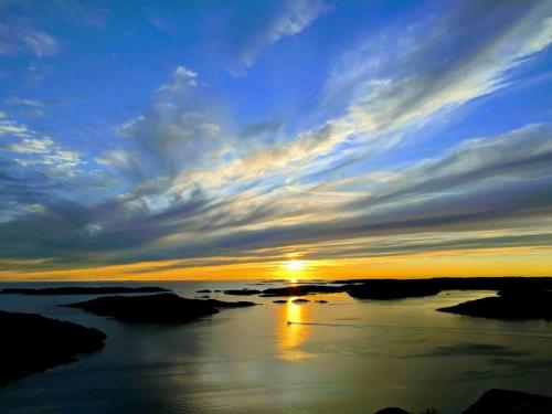 a sunset over a body of water with the sun setting at 6 person holiday home in Bovallstrand-By Traum in Bovallstrand