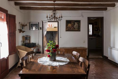 a dining room with a wooden table with flowers on it at Casa Rural Vilaspasa, alquiler integro in Gotarta