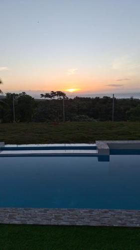 a swimming pool with the sunset in the background at Villa Carlito in Las Terrenas