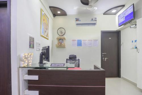 an office with a reception desk and a clock on the wall at Hotel O Shyam Vatika Banquet And Rooms in Surat