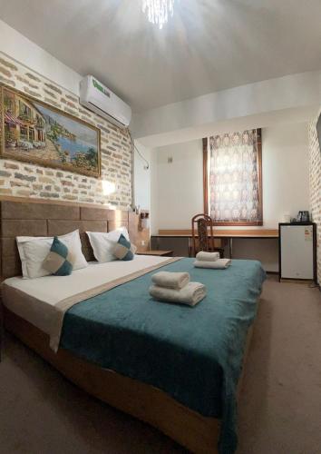 a bedroom with a large bed with towels on it at Hotel Hirot Inn in Tashkent