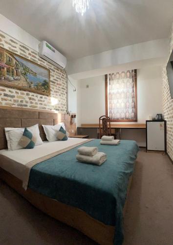 a bedroom with a large bed with towels on it at Hotel Hirot in Tashkent