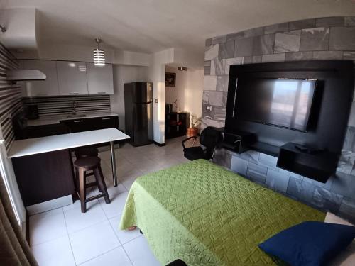 a living room with a kitchen with a tv and a table at Apartamento Ciudad de Guatemala, Zona 4, 1 Parqueo Gratis, Mejor Vista en 4 Grados Norte, 4 Camas in Guatemala