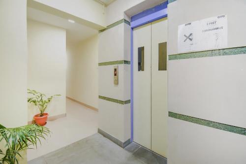 a hallway with a door and a plant at Hotel O Tranquil Stay in Kolkata