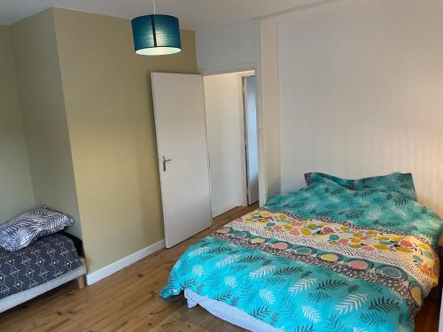 a small bedroom with a bed and a couch at Maisonnette 2 chambres avec cour in Haubourdin