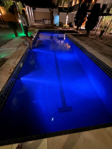 a large blue swimming pool at night at Espaço Vip 600 in Pacatuba