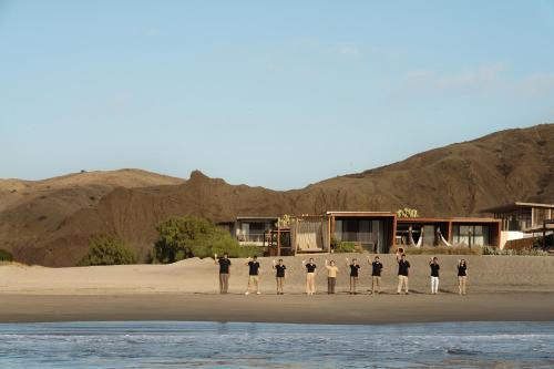 a group of people standing on the beach at Norte Suites Boutique in Los Órganos