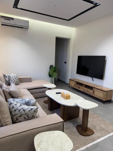a living room with a couch and a flat screen tv at نوفا للشقق الفندقية in Jeddah