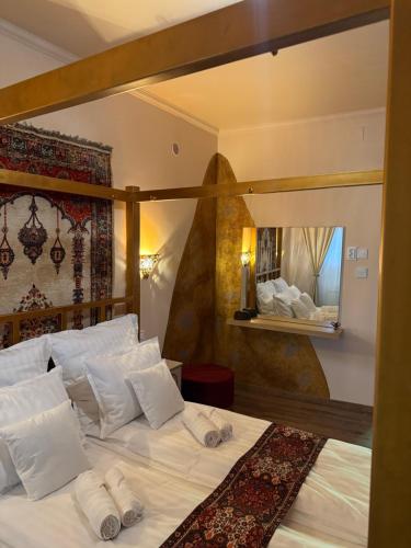 un lit avec des draps blancs et des oreillers dans une chambre dans l'établissement HAREM romantic apartment, à Eger